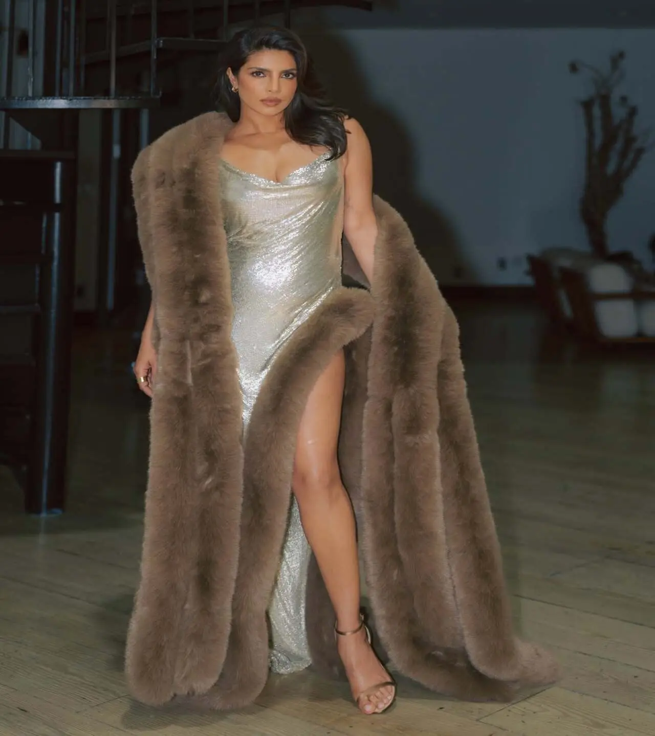 Priyanka's afterparty looked comprised a stunning floor-length metallic gown with a thigh-high slit, a brown fur shrug and gold kitten heels